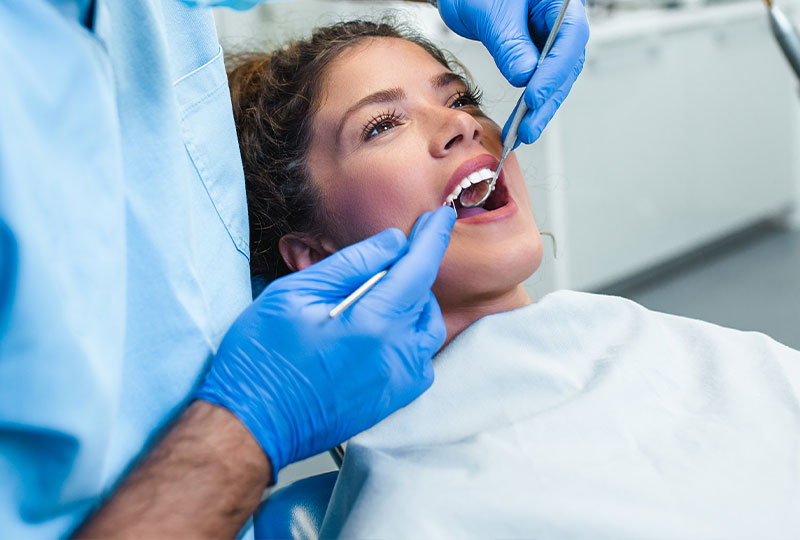 A group of five individuals, possibly dental professionals, in a dental office setting, celebrating with raised hands and thumbs up.